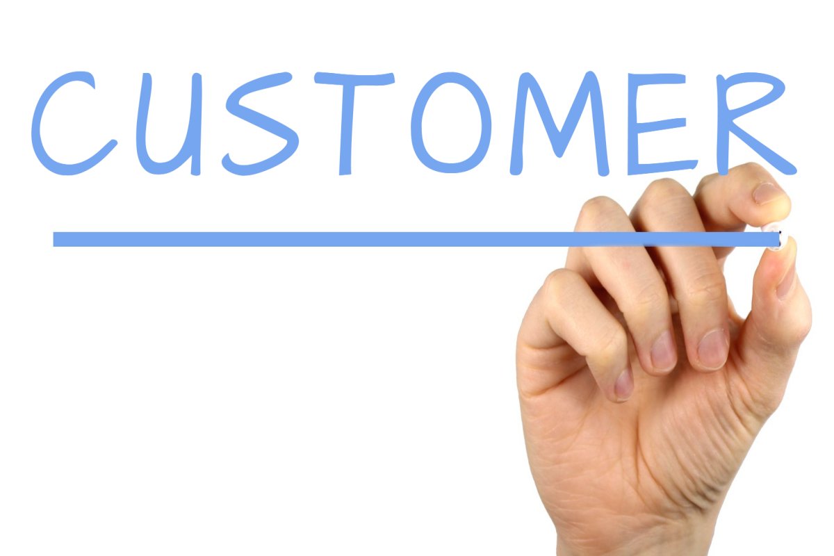 image of hand writing out the word customer in blue
